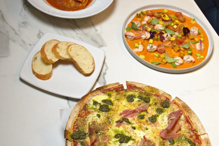 Mesa servida en Buque con pizza, ceviche y cóctel