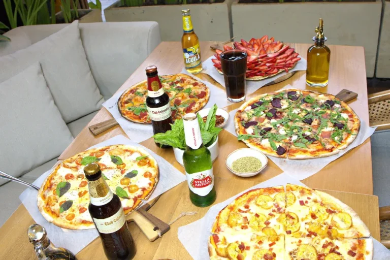 Mesa servida con varias pizzas